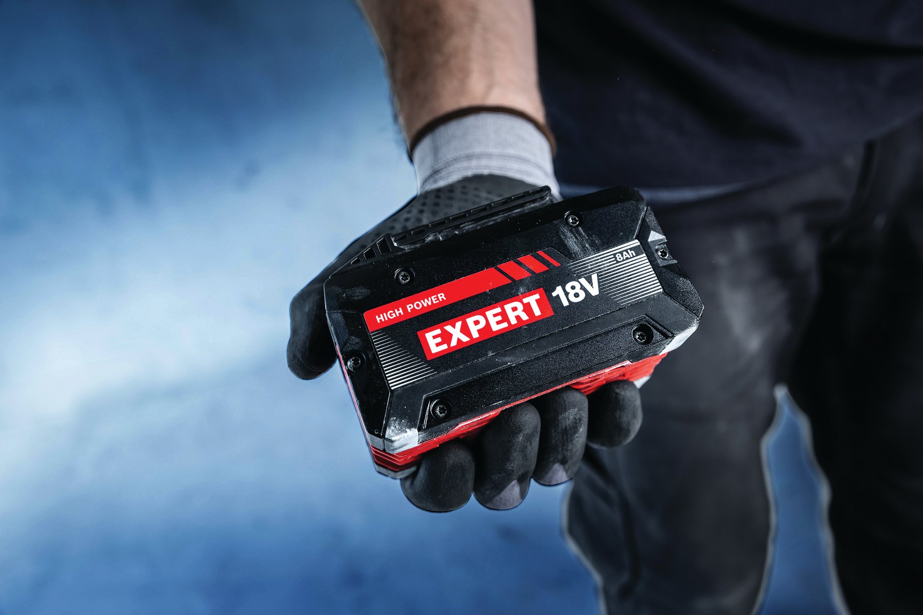 Hand im Arbeitshandschuh hält einen Bosch EXPERT 18V Akku