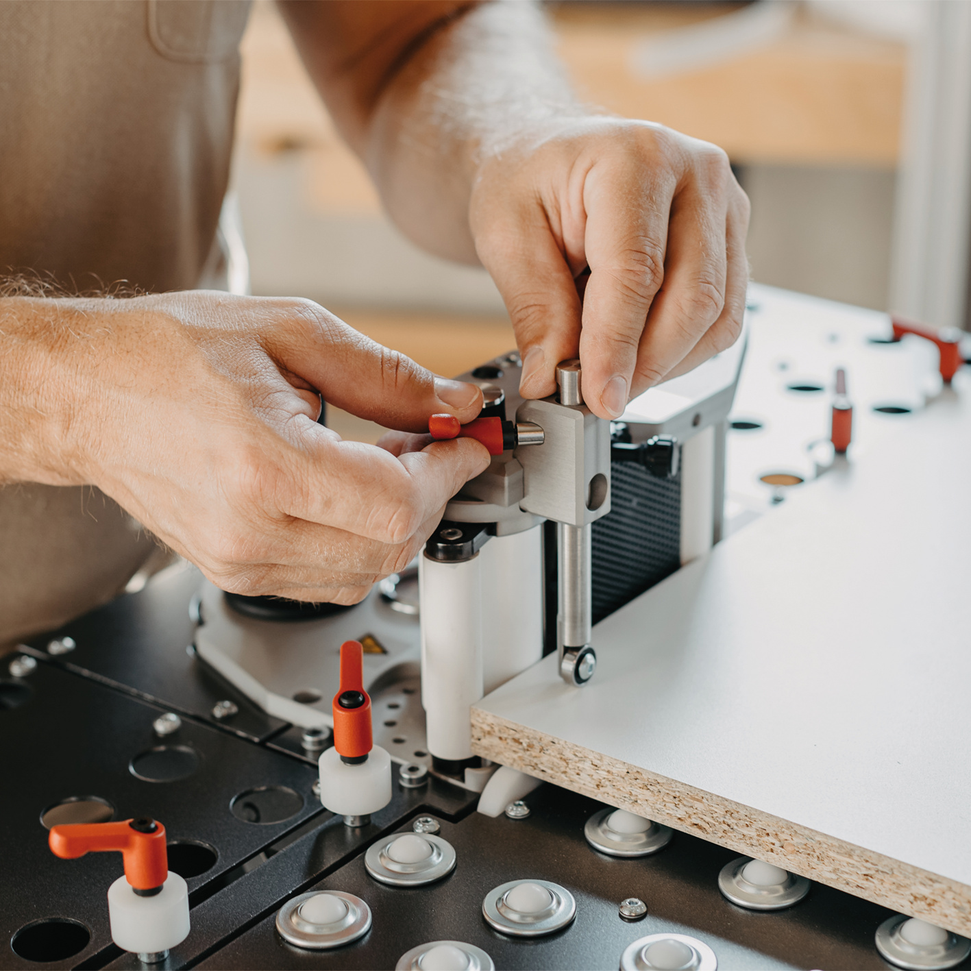 Um die Auflage der Platte auf den Kugelrollen des Bearbeitungstisches BAT zu unterstützen, kann optional der Niederhalter auf die exakte Plattenhöhe eingestellt werden. Anwendungsbild